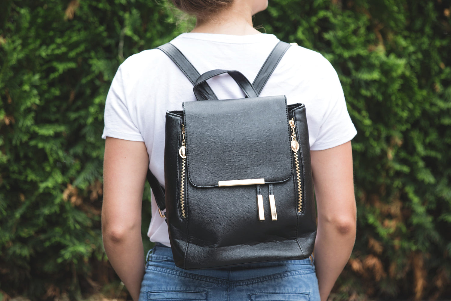 Girl Seen From Behind In White Tshirt And Jeans Wearing Black And Gold Backpack