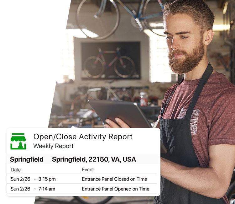 Man Working In Bicycle Shop, Reading Weekly Shop Activity Report On Tablet